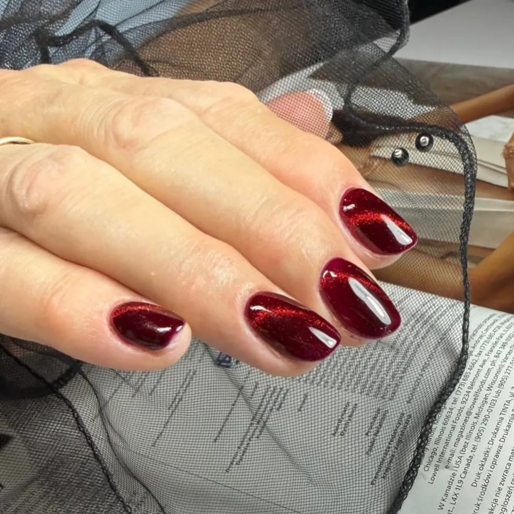 Bordowy manicure żelowy z efektem kociego oka